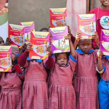 Young learners holding up their new learning materials