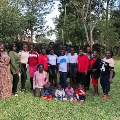 A group of young women and girls gathered outdoors at a BintiCare Teenage Mothers Program meeting