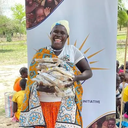 A woman receiving food packets at a Lishe Kwa Mtoto community distribution