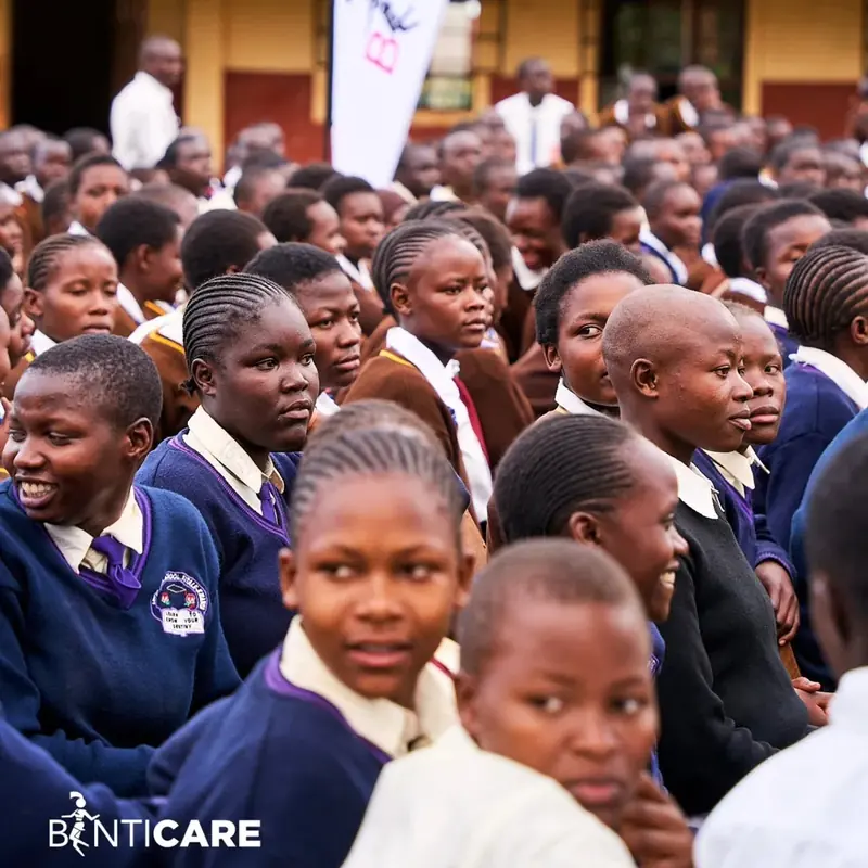 Rows of schoolgirls in navy uniforms listening during a school session