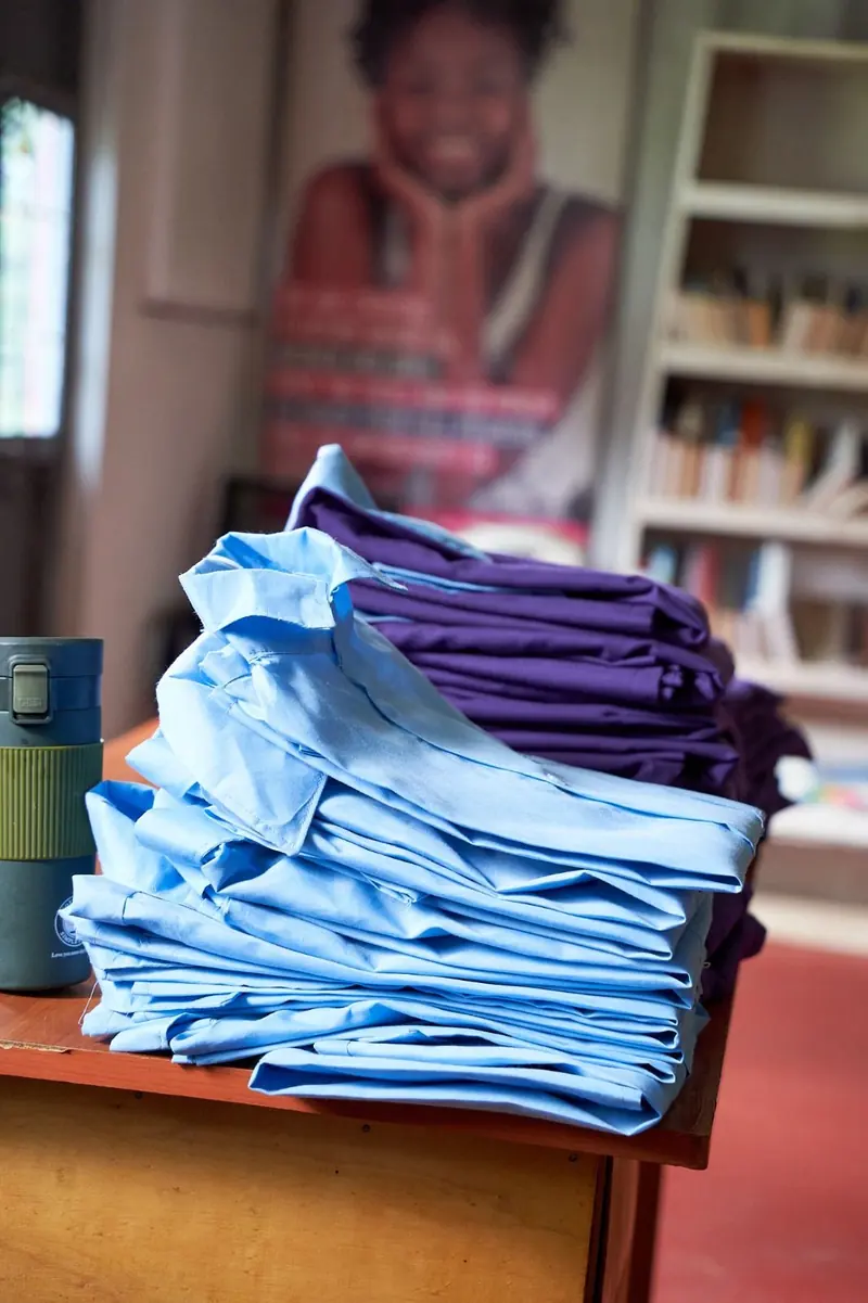 Neatly folded new school uniforms ready for distribution